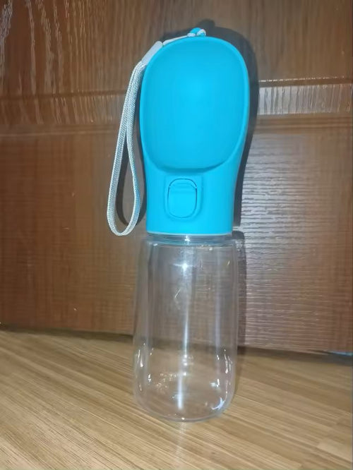 The blue dog water bottle standing upright, showing the cup lid, button and clear body