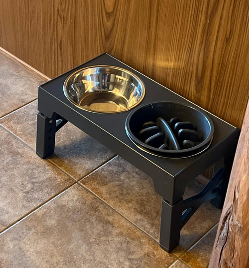 The raised bowl stand on a tiled floor with both bowls in place and the adjustable legs visible