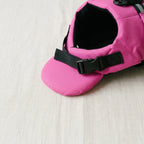 Close-up of the padded pink chin float and black side-release buckle on the dog life jacket