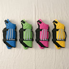 The dog life jacket in all four colours side by side: blue, green, pink and yellow