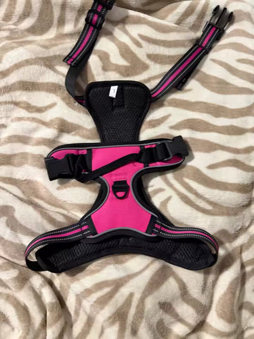 The pink and black harness laid flat, with the front chest ring clearly visible