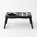 Raised dog bowl stand on a white background with two stainless steel bowls in the folding frame