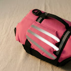 Close-up of the three grey reflective bands on the side panel of the pink dog life jacket